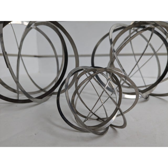 Add a modern touch to your home decor with this striking trio of silver-tone metal spherical balls. Dimensions: The...