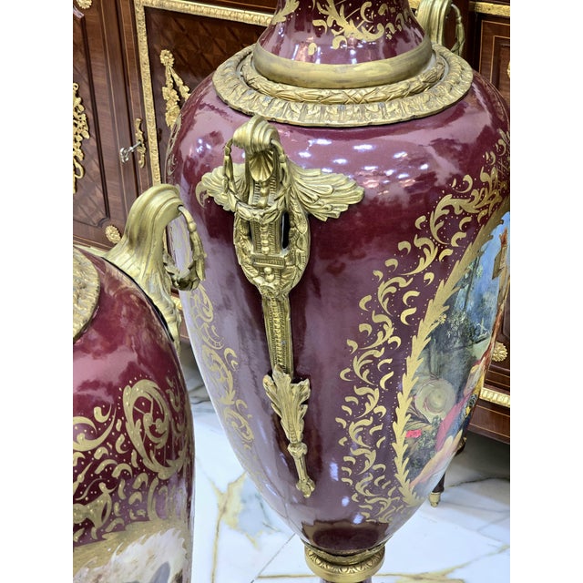 Elegant pair of French porcelain vases, decorated with a multicolored background and delicate galant scenes in reserve....