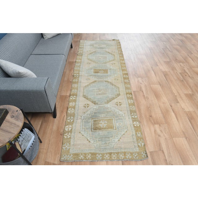 Vintage Hand-Knotted runner rug is a semi-antique vintage area rug. The '70s Eastern region of Anatolia's unique rug is...