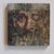 This artwork presents a close-up view of a face, partially obscured by a textured surface that suggests layers of depth...