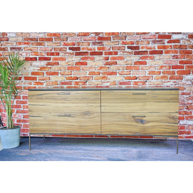 A genuinely striking case piece that walks the line between raw organic material and refined modern design. Four oversized...
