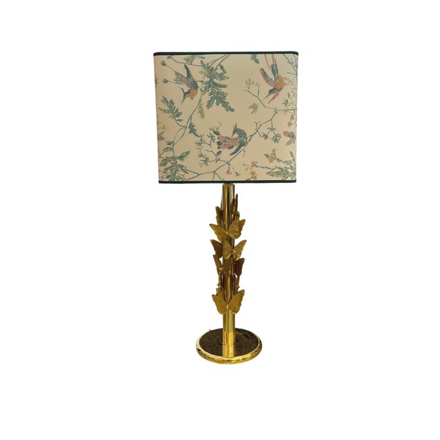 Pair of Murano glass lamps. The base consists of a solid, clear glass structure with a gilded brass shaft. Each butterfly...