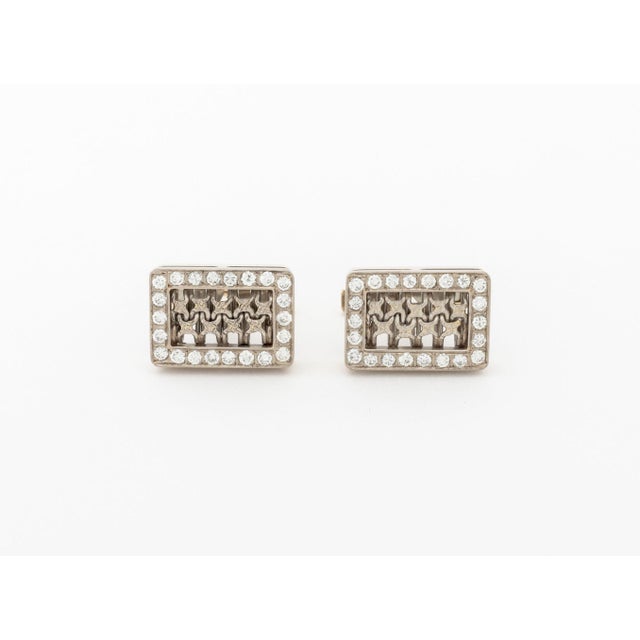 Pair of 18K White Gold and Diamond Cufflinks, designed as diamond set rectangular frames decorated with open work in the...