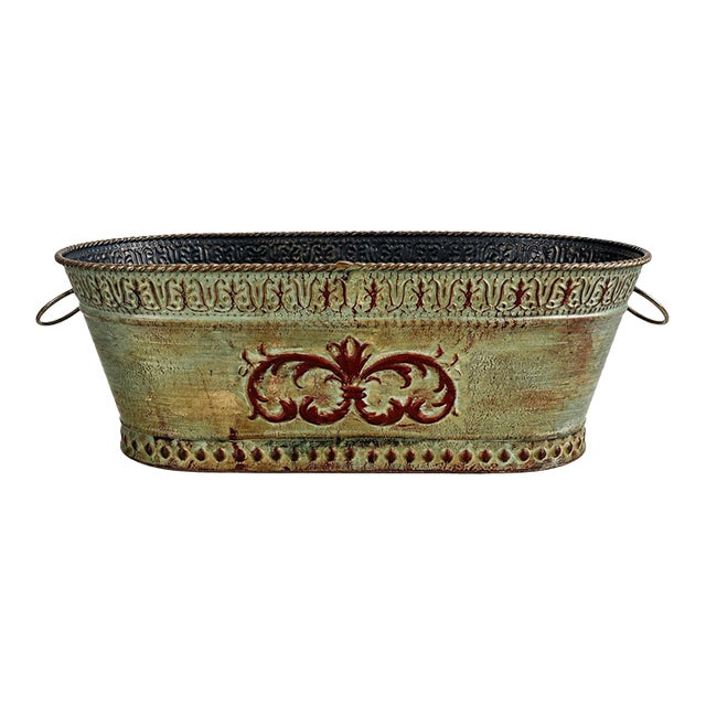 A charming vintage metal jardinière / cachepot with an elongated trough silhouette, ornate embossed detailing, and...