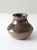 This vintage handmade pottery vase features a warm, earthy glaze with rich brown and reddish tones. Its charming, bulbous...