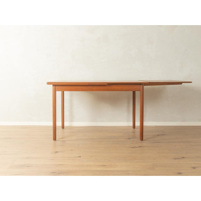 Classic extendable dining table from the 1960s. Solid teak frame and veneered tabletop with a solid wood edge. Quality...