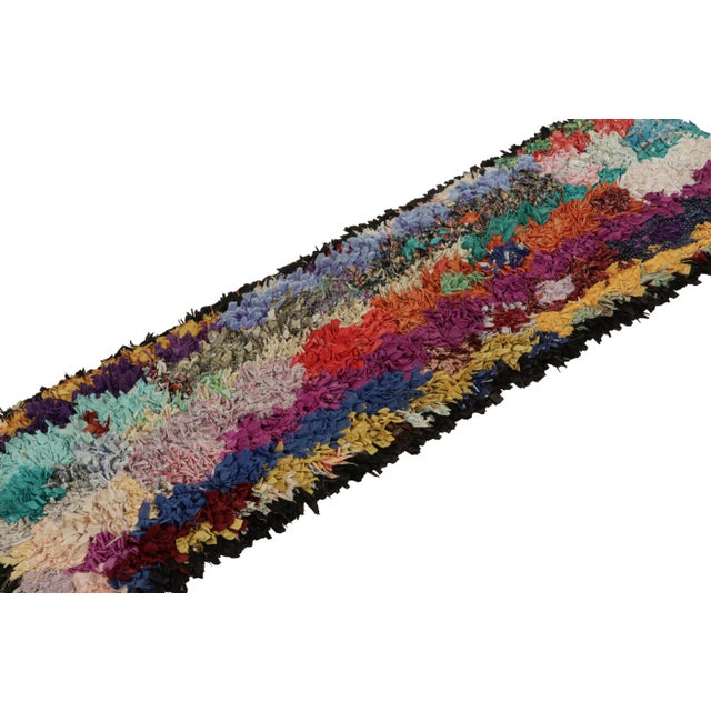 Hand-knotted in fabric, circa 1950-1960, this 3x6 vintage Moroccan Boucherouite runner rug is believed to hail from the...