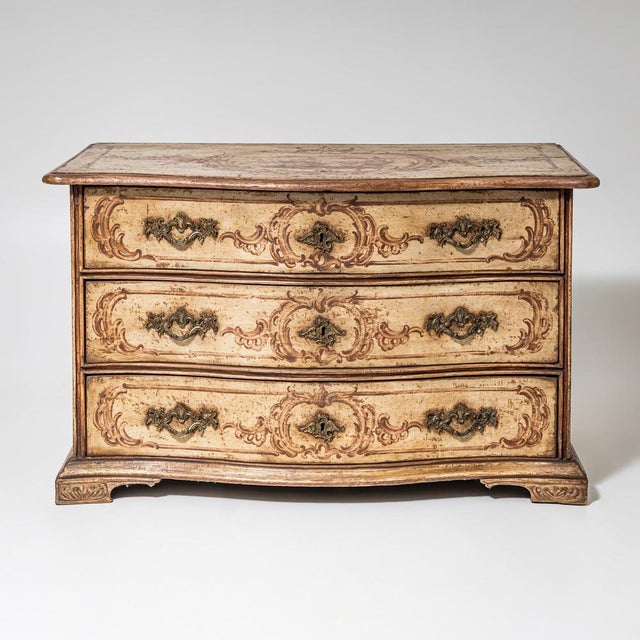 Large Baroque commode with a gently serpentine front and brass mounts. The piece is fitted with three drawers. The commode...
