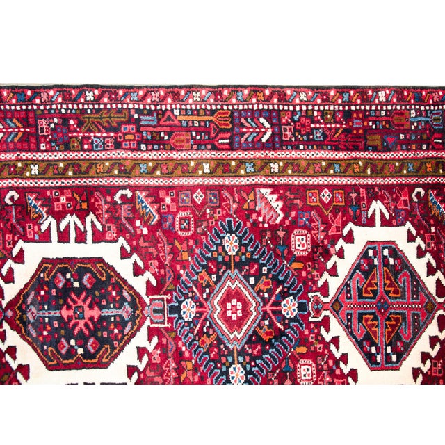 A beautiful MId-20th century Persian Heriz runner with several large stylized floral medallions living amidst a densely...