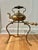 In the Victorian Era, these kettles on stands were used for keeping water warm near the fire for household use. This one...