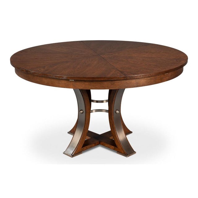 Warm wood and iron-banded supports establish a substantial center beneath the circular top. A curved four-post pedestal...