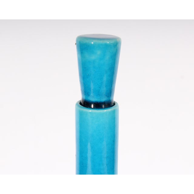 A Rörstrand Sweden blue ceramic bottle with stopper. The blue glazed decanter features a narrow neck and oblong body with...