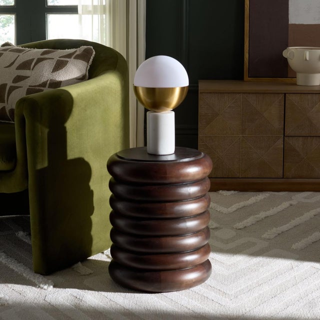 Introduce a touch of timeless elegance into your living space with the Anatoly Round Accent Table in brown. This charming...