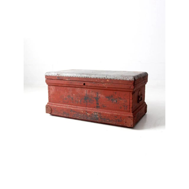 This antique wooden chest is a captivating addition to any living or storage space. Painted barn red, the chest is built...