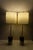 A sophisticated pair of contemporary table lamps crafted from striking black and white stone with brass finish fittings...
