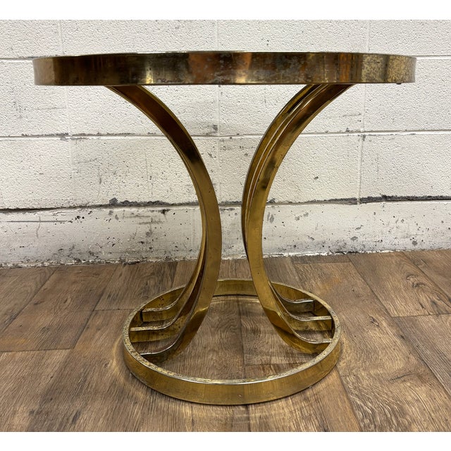 This is an absolutely stunning vintage Hollywood Regency or Art Deco tulip or Milo Baughman style brass and glass side...