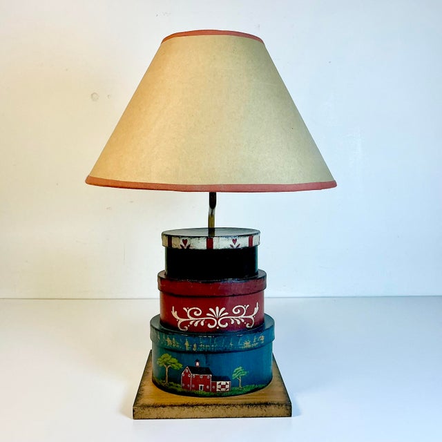 This accent table lamp is delightful. It has an Arts & Crafts style featuring a stack of three little storage boxes with...