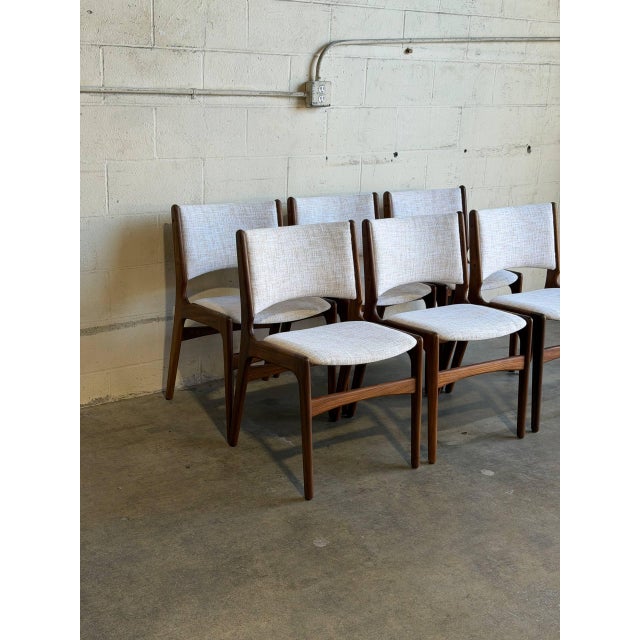These organic dining chairs showcase curved floating seat pads and contoured backrests crafted from warm solid rosewood...
