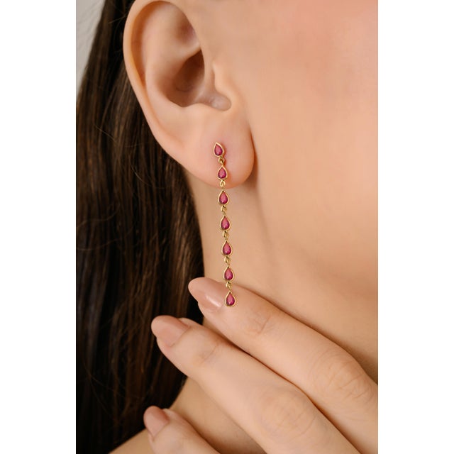 These elegant long drop earrings are crafted in 14K solid yellow gold, featuring a total of 2.31 carats of pear shaped...