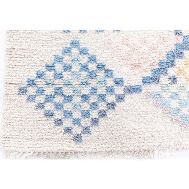 1950's Swedish Pile Rug Size: 5'5" × 8'3" (165 × 251 cm) Color: Beige, Blue, Orange Origin: Sweden This captivating...