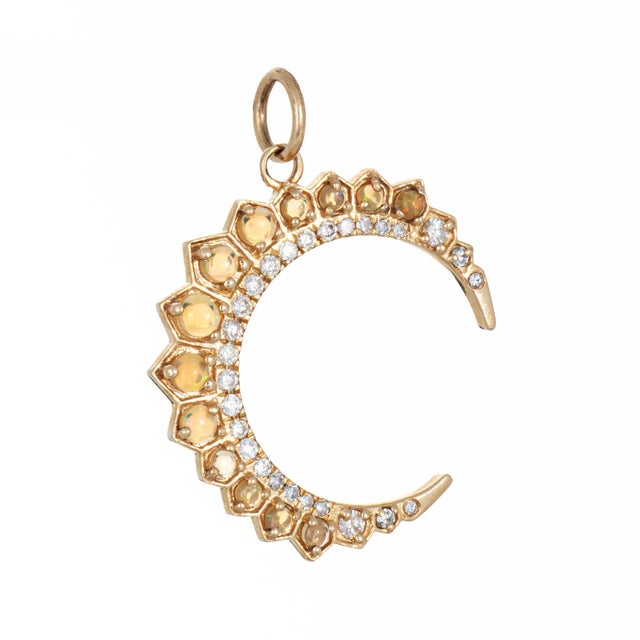 Stylish opal & diamond crescent moon pendant crafted in 14 karat yellow gold. Diamonds total an estimated 0.15 carats...