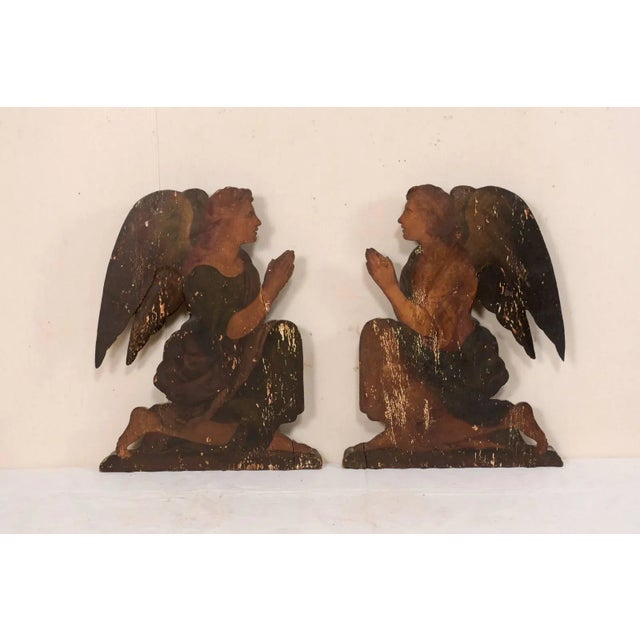 A pair of Italian 19th century painted wood angel plaques. This pair of antique Italian plaques, perhaps originally used...