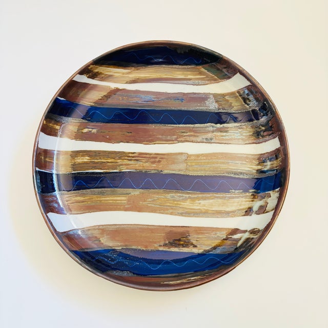 A large ceramic serving platter by Dansk. Features a blue and brown striped design. Nice large size for a variety of...