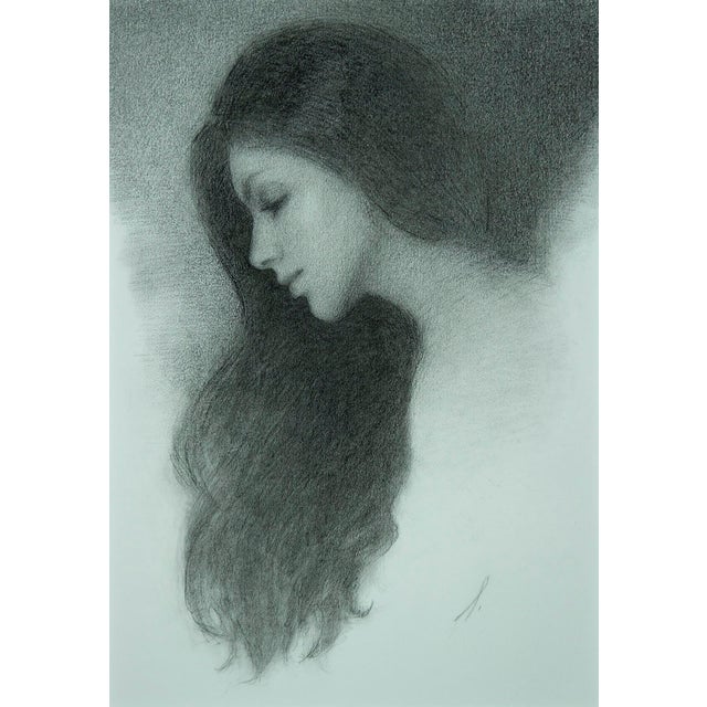 This charcoal drawing captures the serene profile of a woman, her flowing hair merging softly into the background. The...