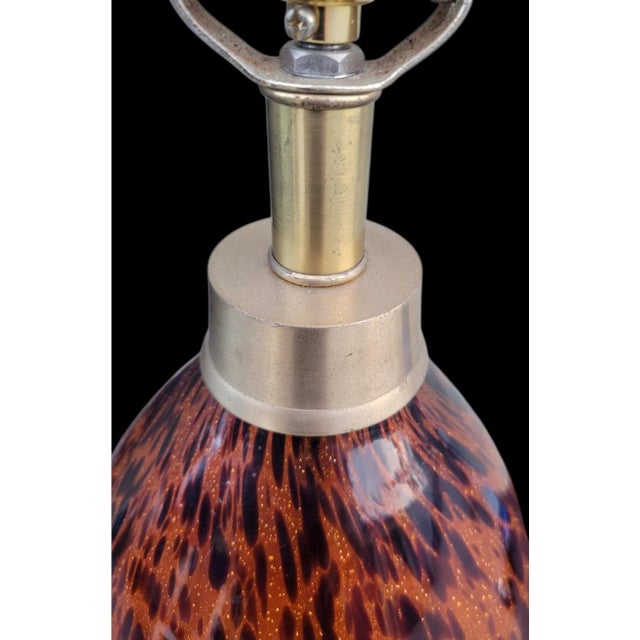 A gorgeous blown glass faux tortoiseshell table lamp. The lamp features a pale gold base and neck with a glass blown body....