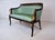 A classic French Empire Style curved back settee with distinct Neoclassical design elements in the carved gold dolphin...