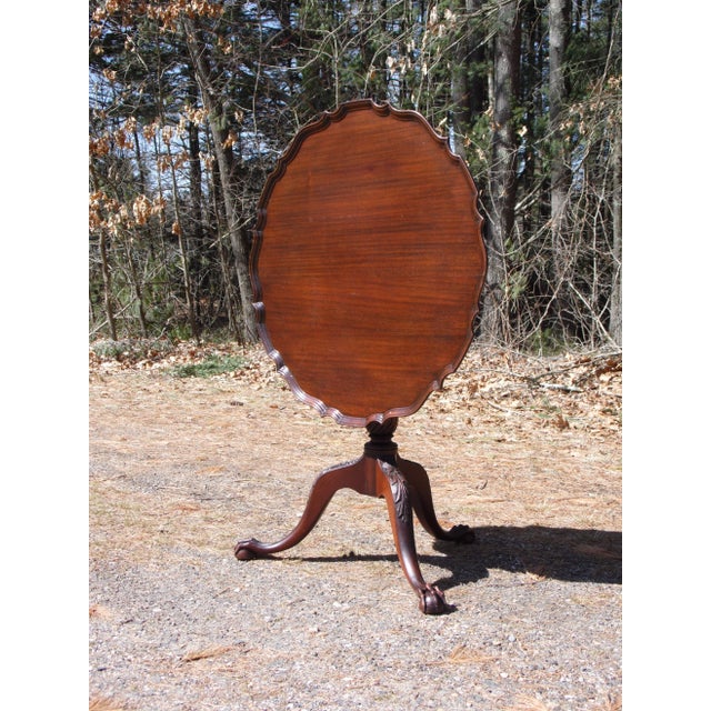 Vintage Charak Chippendale Style Mahogany Pedestal Base Pie Crust Tilt Top Table features a sculptural ogee edge top,...