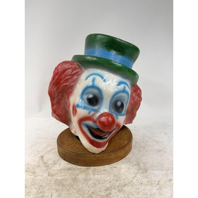 Charming decorative sculpture depicting a smiling clown wearing a colorful top hat, finished with hand-painted details and...