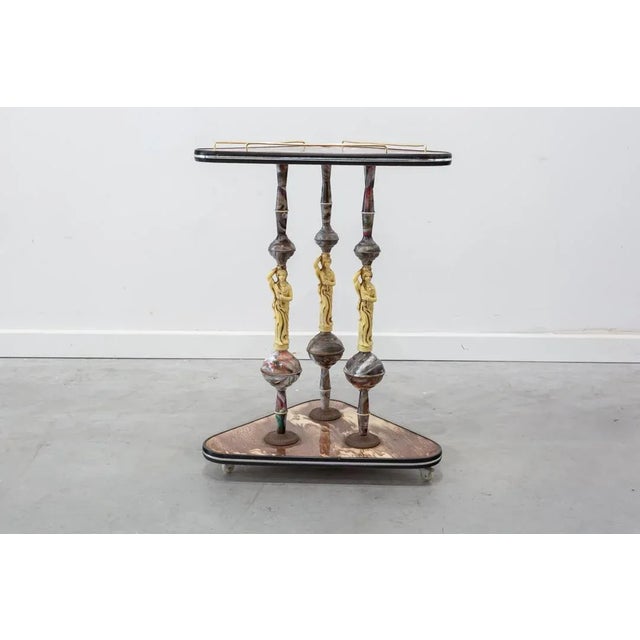 Veverer in two heights triangular made in conglomerate and plastic imitating marble. Three legs in the form of Atlantes,...