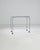A metal table on wheels, circa 1960s France. Crisscrossing metal rods, fit with cap nuts, snap together to construct this...
