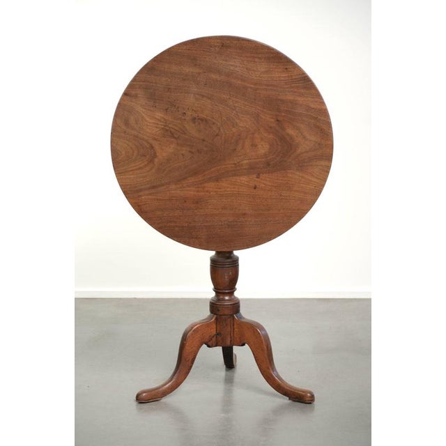 This charming antique English tilt-top table dates from the 19th century and features beautiful colors and a stunning...