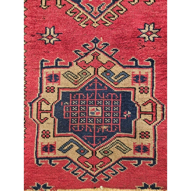 A finely woven vintage Turkish village runner from the early 20th century featuring a bold geometric medallion design...