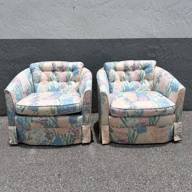 A fabulous pair of vintage Postmodern swivel barrel chairs showcasing a playful pastel floral upholstery in shades of sky...