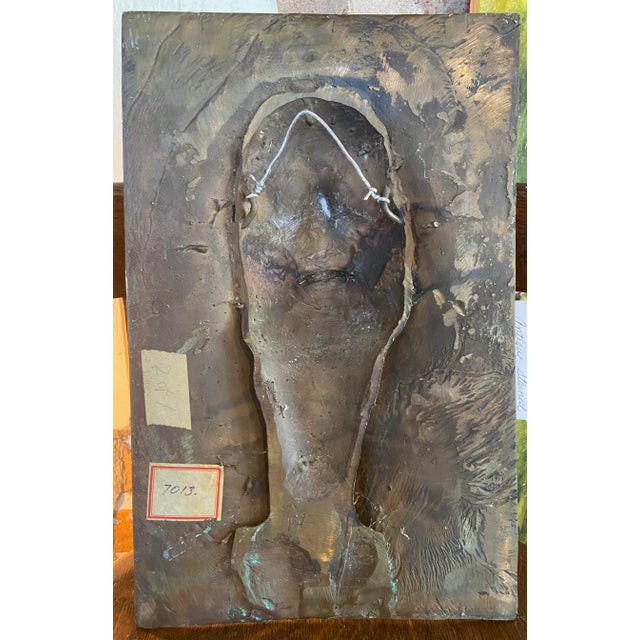 William Ludwig original signed emerging face bronze relief wall sculpture. The piece features a face emerging from a...