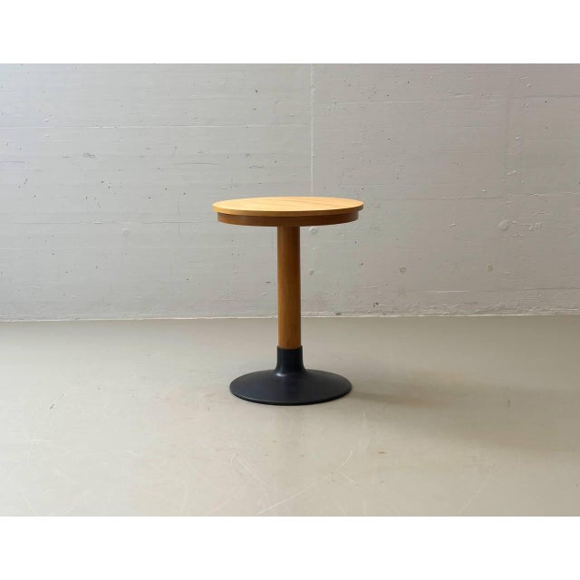 An elegant side or bistro table with a clean, timeless design and a beautiful combination of wood and black lacquered cast...