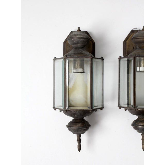 A pair of vintage outdoor wall lanterns with a classic Colonial Revival form, featuring clear glass panels and a softly...