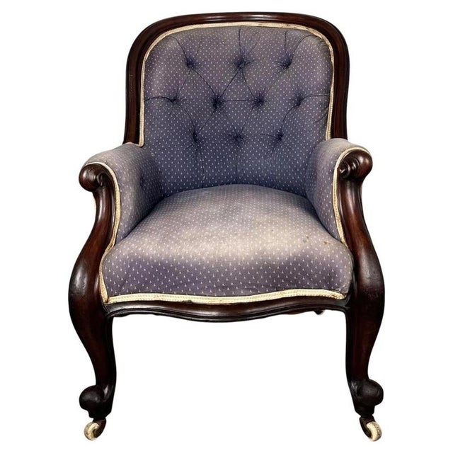A handsome 19th-century English button-back armchair crafted from mahogany, combining classic Victorian styling with...
