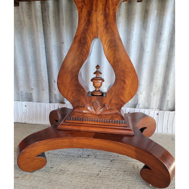 Beautiful 19th century flame mahogany Empire game table. Classic Empire style base with lyre pedestal. Flips open to...