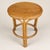 Late 20th century round occasional table in warm honey-toned bamboo and rattan with a fitted wood inset top. Three bundled...