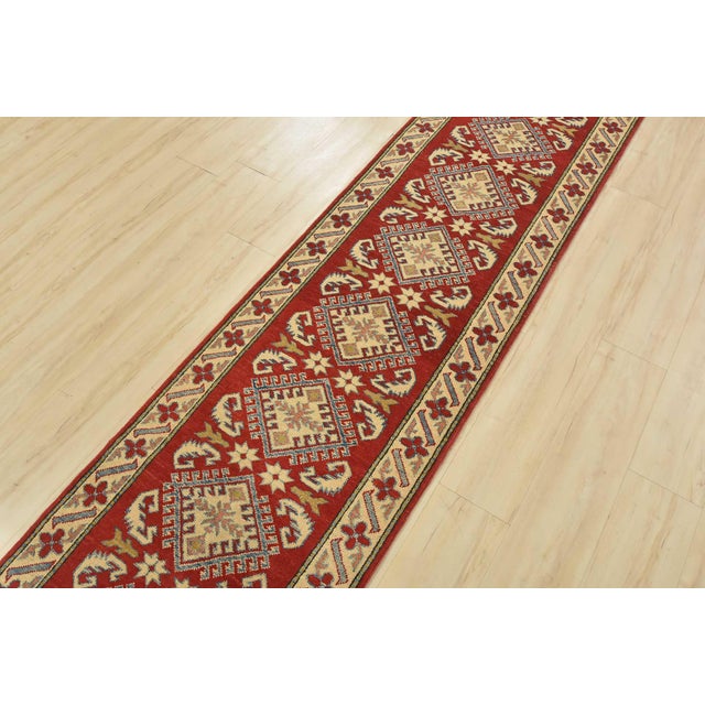 This traditional tribal geometric Caucasian Kazak runner is hand-knotted with an all-wool pile on a cotton foundation....