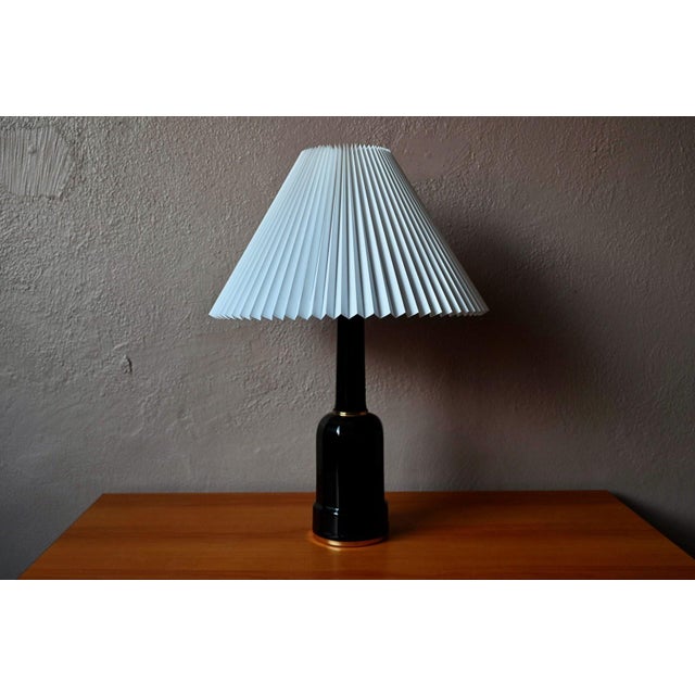 An iconic Danish lamp, this superb version in black porcelain and brass dates from the 1950s. with its elegant, sculptural...