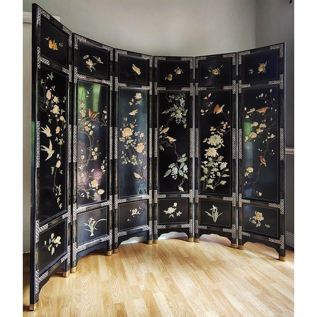 This gorgeous Chinese lacquered screen is intricately carved with stones and mother of pearl featuring birds, peaches,...