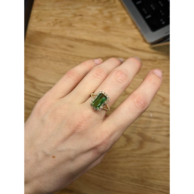 A beautiful engagement ring made with 14K yellow gold. The centerpiece of the ring features a 2.93-carat chrome tourmaline...