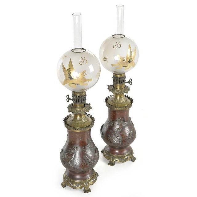Elegant and theatrical, these napoleon iii style oil lamps are a rare decorative pair combining blown glass, bronze and...