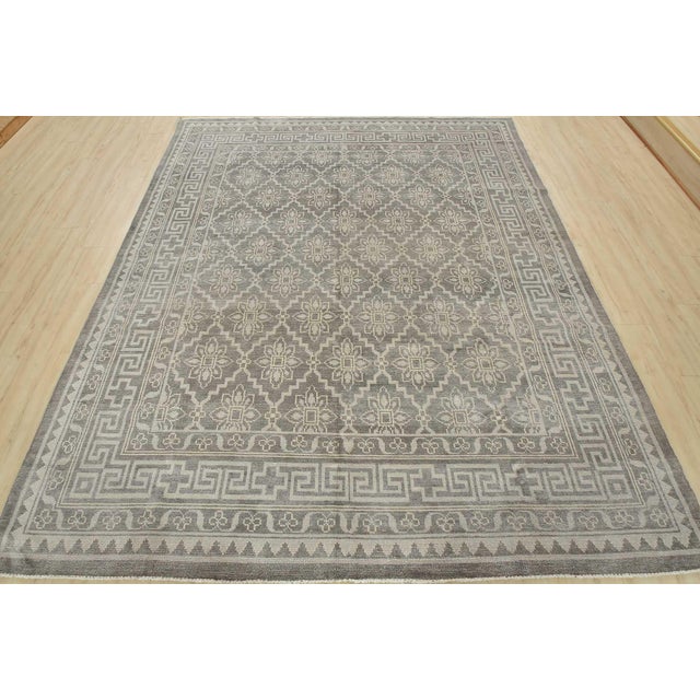 A modern traditional oriental rug hand-knotted with an all-wool pile on a cotton foundation. This area rug features an...