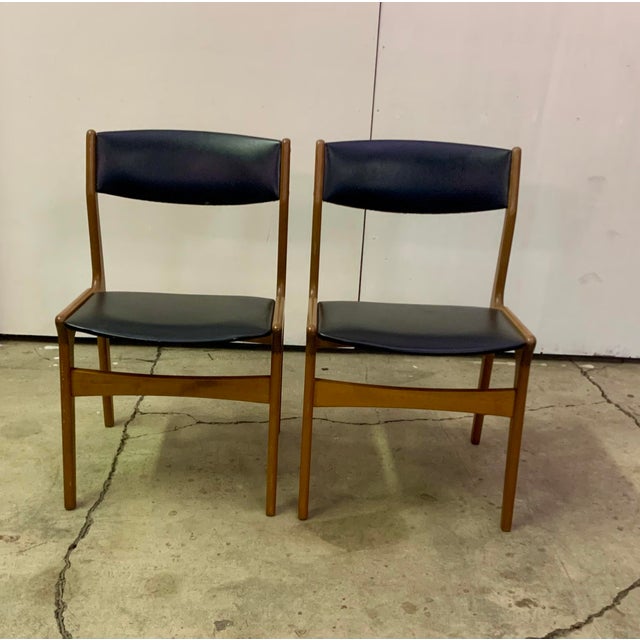 A pair of vintage unmarked erik buch dining chairs crafted in richly toned teak. Sculptural frames with elegant...